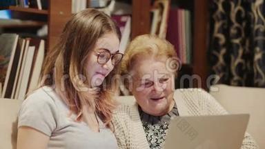 一位年轻女士帮一位年长的女士拿着笔记本电脑